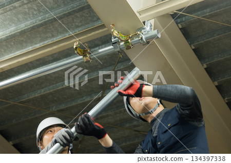 工人們在工廠工地組裝單管管道 134397338