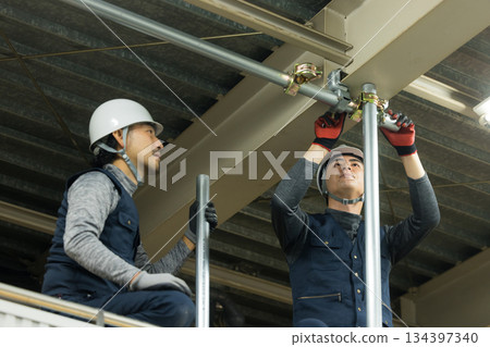 工人們在工廠工地組裝單管管道 134397340