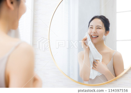 年輕女子在浴室照鏡子 134397556