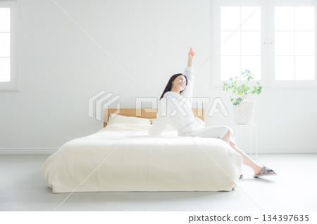 A woman sitting on a bed A woman sitting on a bed 134397635