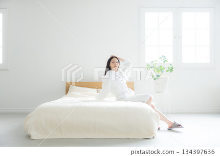 一個女人坐在床上 134397636