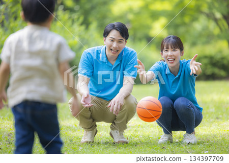 Male and female staff in blue polo shirts playing with children 134397709