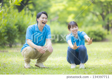 身穿藍色polo衫的男女工作人員正在和孩子們玩耍 身穿藍色polo衫的男女工作人員正在和孩子們玩耍 134397711
