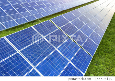 Surface of solar photo voltaic panels system producing renewable clean energy on green grass background. 134398149
