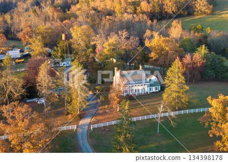 Spacious rural houses among yellow fall foliage in South Carolina suburbs. Beauty of seasonal colors in quiet countryside aria. 134398178