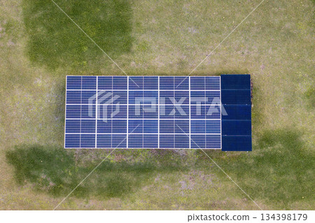 Solar photovoltaic panels mounted on stand-alone frame on backyard ground for generating of clean ecological electric energy Solar photovoltaic panels mounted on stand-alone frame on backyard ground for generating of clean ecological electric energy 134398179