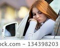 Sad woman driver looking out of a car window. 134398203
