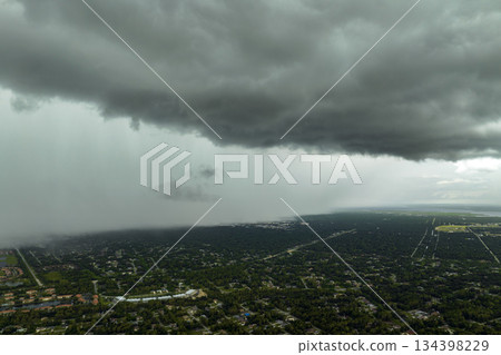 Rainstorm shower over Florida rural town in humid summer season. Rain water pouring down from stormy clouds 134398229