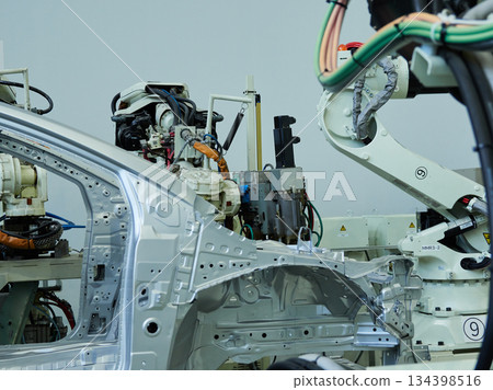A welding robot in action at a site where car bodies are welded A welding robot in action at a site where car bodies are welded 134398516