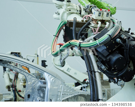 A welding robot in action at a site where car bodies are welded A welding robot in action at a site where car bodies are welded 134398538