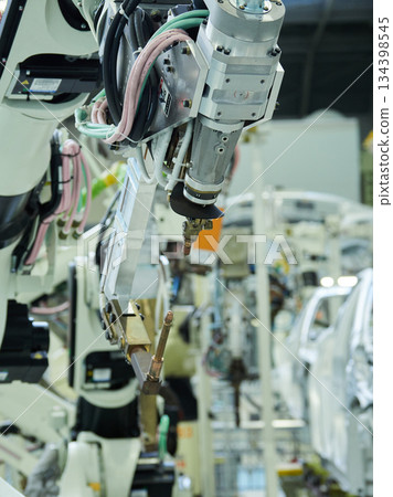 A welding robot in action at a site where car bodies are welded 134398545