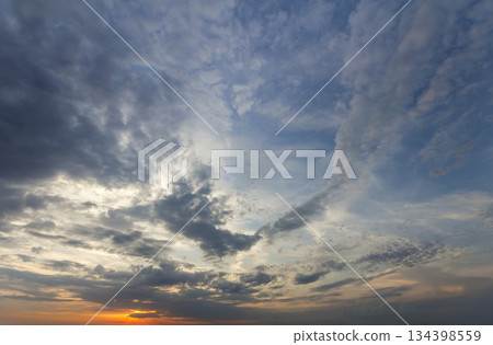 Panorama of sky at sunrise or sunset. Beautiful view of dark blue clouds lit by bright orange yellow sun on clear sky. Beauty and power of nature, meteorology and climate changing concept. Panorama of sky at sunrise or sunset. Beautiful view of dark blue clouds lit by bright orange yellow sun on clear sky. Beauty and power of nature, meteorology and climate changing concept. 134398559