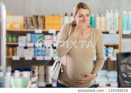 Pregnant woman visits pharmacy and suffers from nausea Pregnant woman visits pharmacy and suffers from nausea 134398639