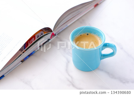 一個人一邊喝著現煮的咖啡一邊放鬆並享受一本書的圖片。 134398680