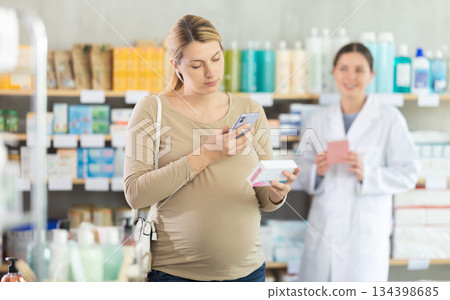 Pregnant woman buyer scans pills qr code with woman pharmacist 134398685