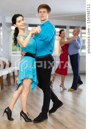 Woman paired with male partner dance samba in dance class with students 134398711
