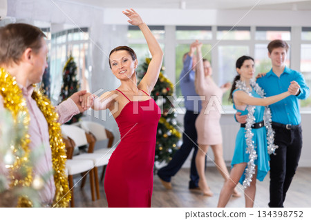 Woman in red enjoying passionate salsa with colleague at corporate Christmas party Woman in red enjoying passionate salsa with colleague at corporate Christmas party 134398752