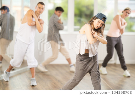 Group of young hip-hop dancers rehearsing in studio. Dancers full of energy Group of young hip-hop dancers rehearsing in studio. Dancers full of energy 134398768