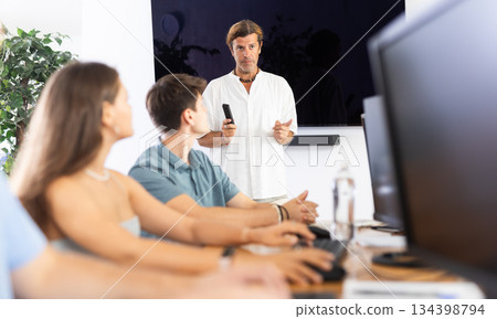 Experienced mentor explaining assigned tasks to young developers at IT startup Experienced mentor explaining assigned tasks to young developers at IT startup 134398794