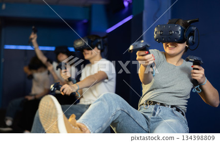 Happy woman is fascinated by movie in virtual reality glasses in room 134398809