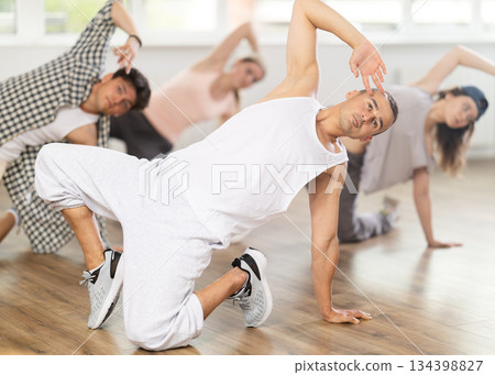 Group of young friends learn group dances - hip-hop and breakdance in dance studio Group of young friends learn group dances - hip-hop and breakdance in dance studio 134398827