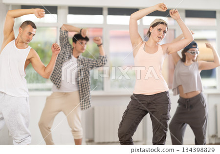 Young girl practicing basic hip hop moves in training hall 134398829