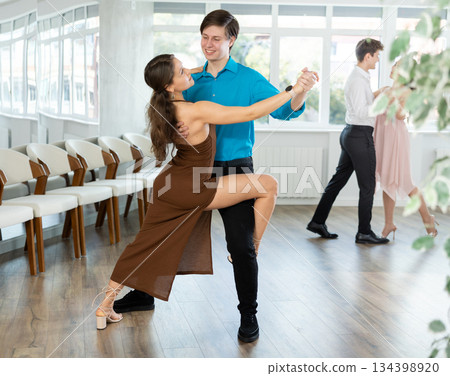 Graceful young duet dancing passionate tango at dance class Graceful young duet dancing passionate tango at dance class 134398920