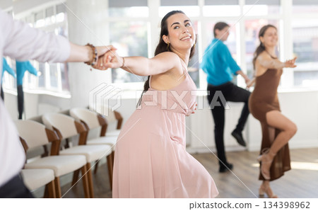Young woman with partner dancing twist 134398962
