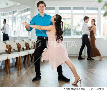 Elegant young couple performing expressive tango in dance studio 134398991