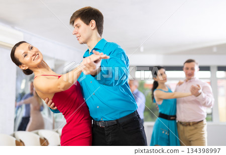 Pair dances - men and women in festive attire dance tango Pair dances - men and women in festive attire dance tango 134398997