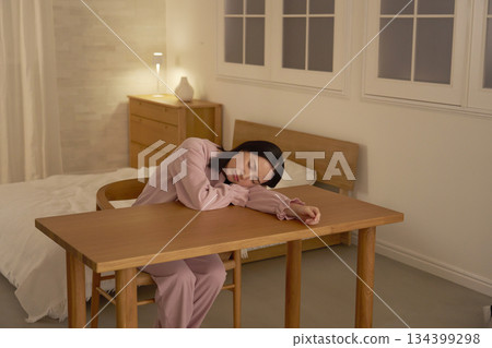 Woman dozing off in a chair at night Woman dozing off in a chair at night 134399298