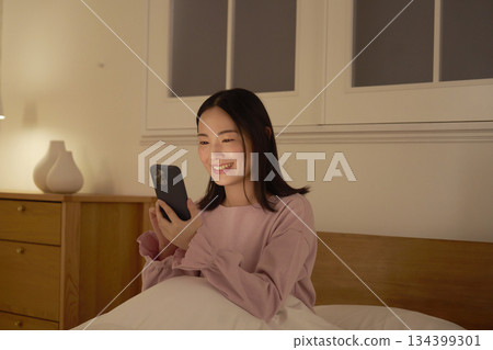 一個在床上使用智能手機的女人 134399301
