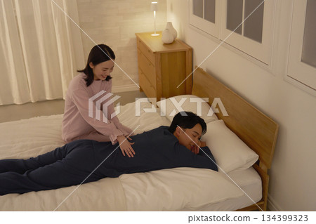 Wife massaging her husband on the bed 134399323