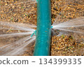 Water leaking from hole in a industrial hose. 134399335