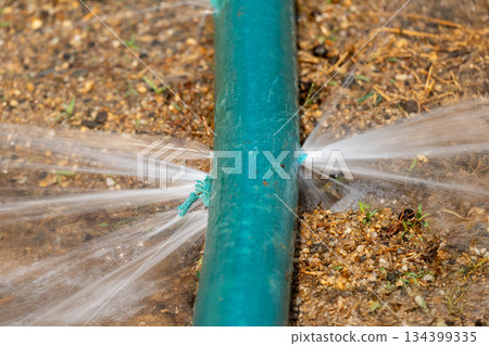 Water leaking from hole in a industrial hose. 134399335
