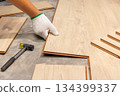 Worker Installing Interlocking laminate floor, home renovation. 134399337