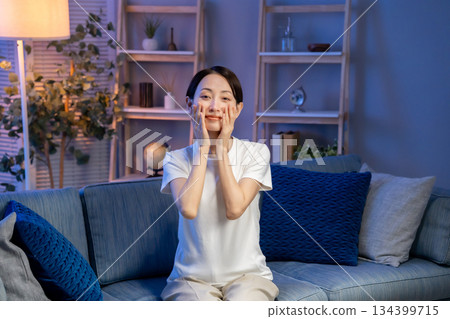 A woman doing skin care in the living room A woman doing skin care in the living room 134399715
