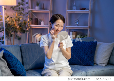 一位女子對著手鏡微笑 134399722
