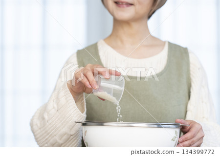 Hands of a senior woman preparing to cook rice in the kitchen Hands of a senior woman preparing to cook rice in the kitchen 134399772