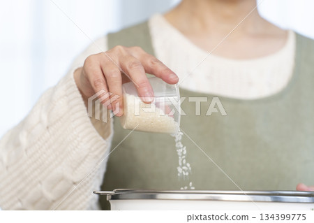 一位老婦人在廚房準備煮飯。 134399775