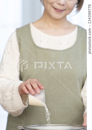 一位老婦人在廚房準備煮飯。 一位老婦人在廚房準備煮飯。 134399776