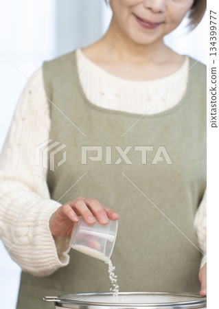 一位老婦人在廚房準備煮飯。 一位老婦人在廚房準備煮飯。 134399777