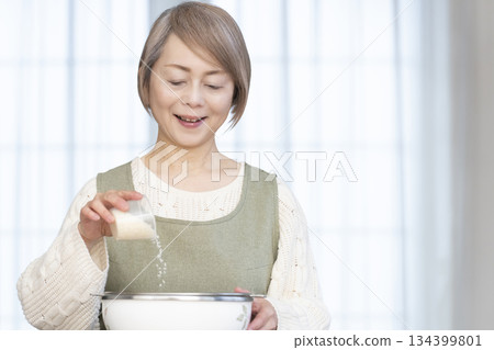Senior woman preparing to cook rice in the kitchen Senior woman preparing to cook rice in the kitchen 134399801