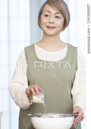 Senior woman preparing to cook rice in the kitchen Senior woman preparing to cook rice in the kitchen 134399807