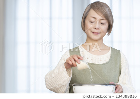 Senior woman preparing to cook rice in the kitchen Senior woman preparing to cook rice in the kitchen 134399810