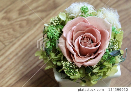 A lovely rose arrangement on a wood grain background 134399930