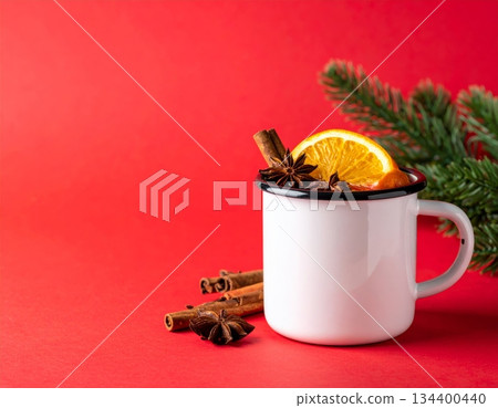 Hot Christmas mulled wine drink with fresh orange and spices in a glass cup on white Hot Christmas mulled wine drink with fresh orange and spices in a glass cup on white 134400440