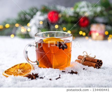 Hot Christmas mulled wine drink with fresh orange and spices in a glass cup on white Hot Christmas mulled wine drink with fresh orange and spices in a glass cup on white 134400441