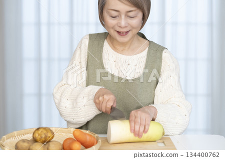 老婦人在廚房削蔬菜 老婦人在廚房削蔬菜 134400762