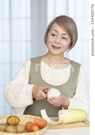老婦人在廚房削蔬菜 老婦人在廚房削蔬菜 134400779